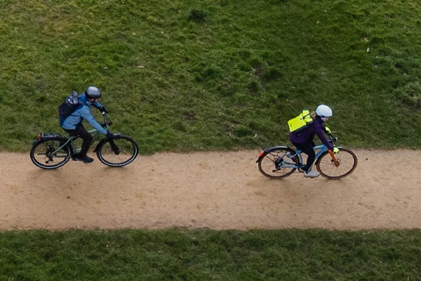 Two riders on Spcialized electric bikes riding along a path